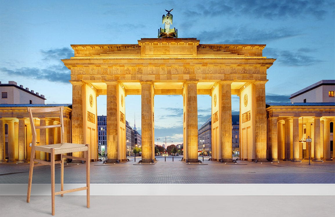 Illuminated Brandenburg Gate mural wallpaper with wooden chair, grey floor, modern room setting.