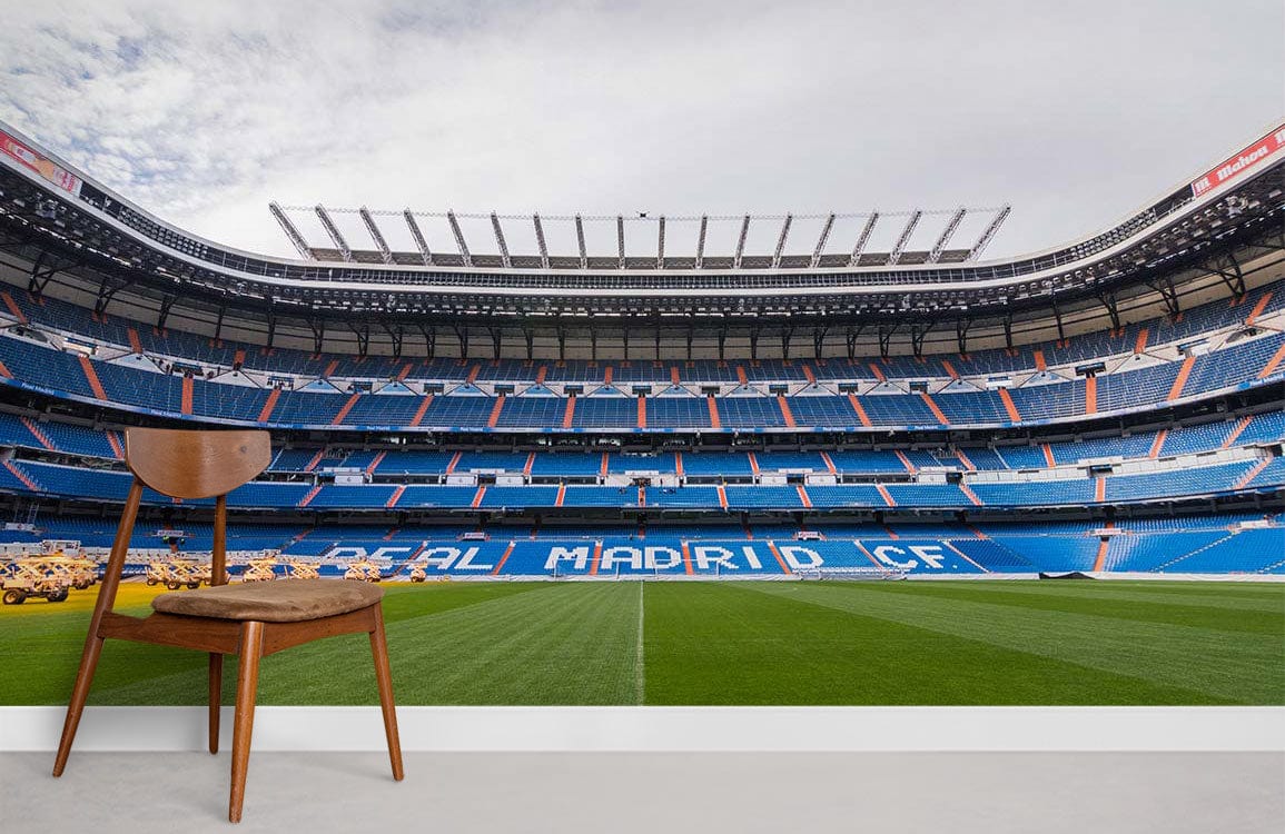 Real Madrid Stadium Mural Wallpaper in a modern room with wooden chair on grey flooring.