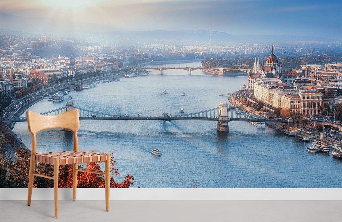 Panoramic Budapest River View mural wallpaper, autumn colours, wooden chair, grey flooring, serene ambience.