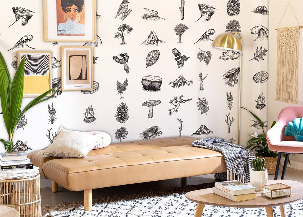 Monochrome vintage wilderness wallpaper in lounge with tan sofa, wooden flooring and framed wall art.