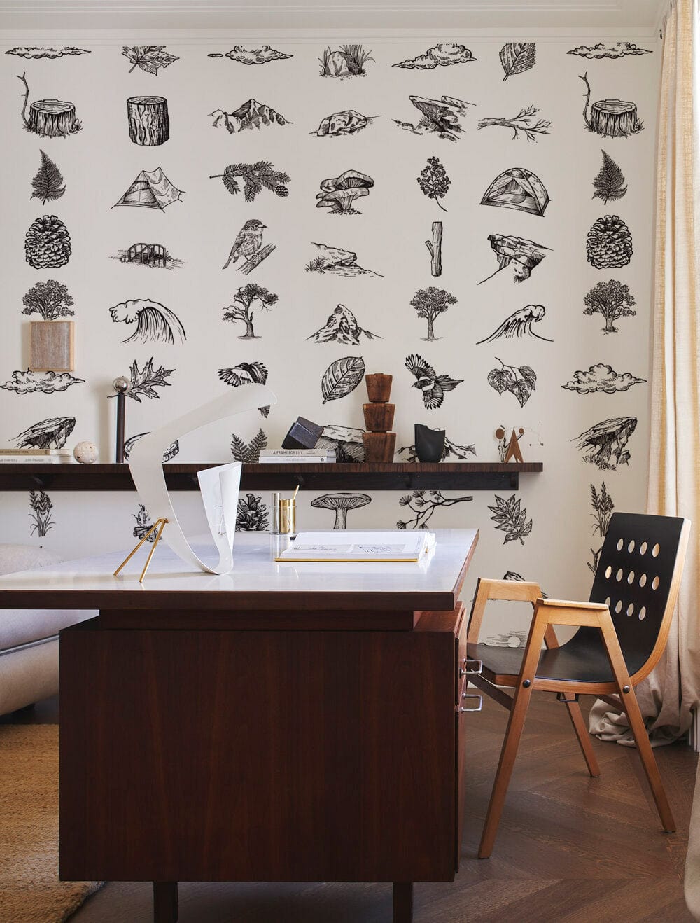 Monochrome vintage wilderness sketch wallpaper in rustic room, featuring wooden furniture and neutral curtains.