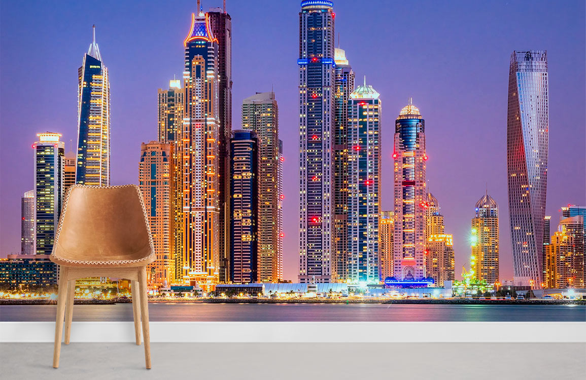 Vibrant cityscape mural wallpaper with illuminated skyscrapers, featuring tan chair, light grey flooring.