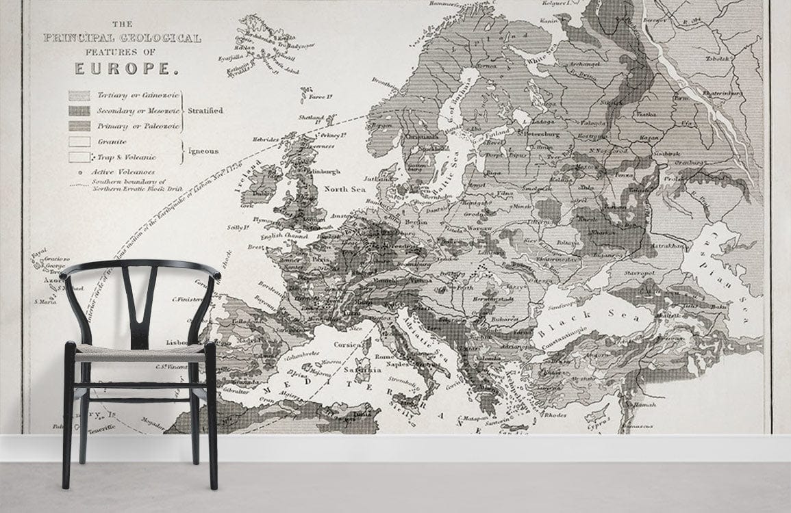 Vintage European geological map wallpaper in monochrome with black chair, grey flooring in living room.