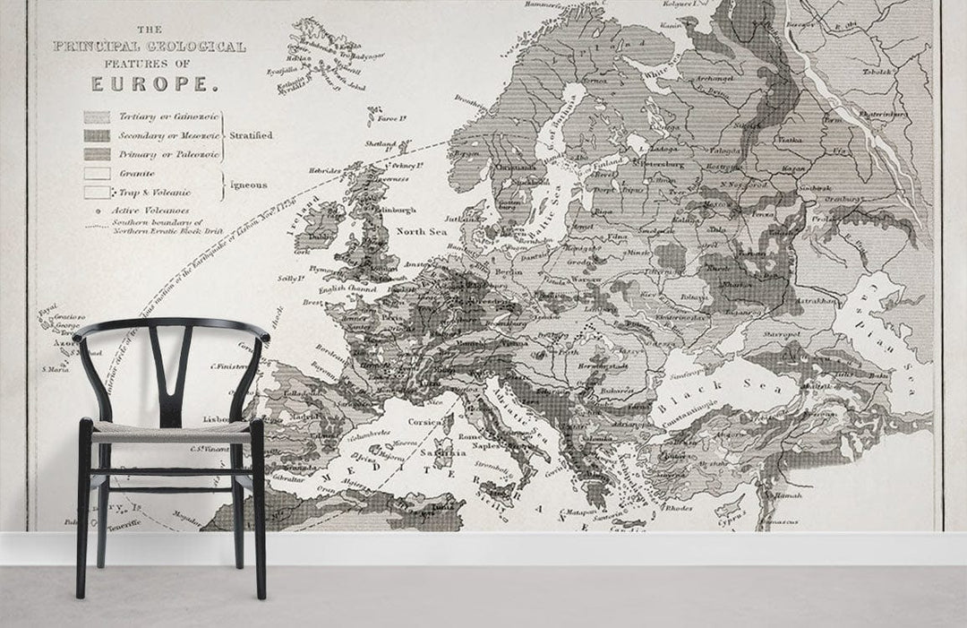 Vintage European geological map wallpaper in monochrome with black chair, grey flooring in living room.