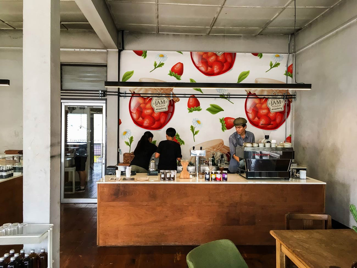 Strawberry jam pattern wallpaper in rustic kitchen with wooden flooring and bar counter. Vintage decor style.