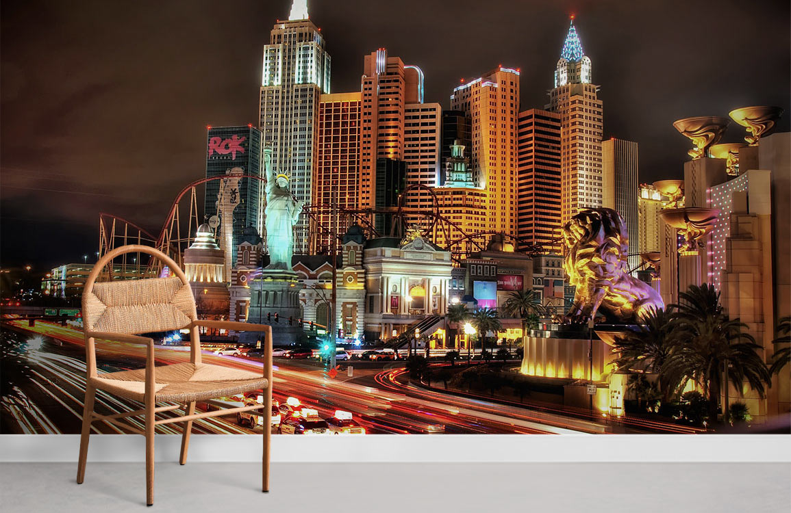 Vibrant Las Vegas skyline mural wallpaper featuring neon highlights, neutral room, brown chair, light flooring.
