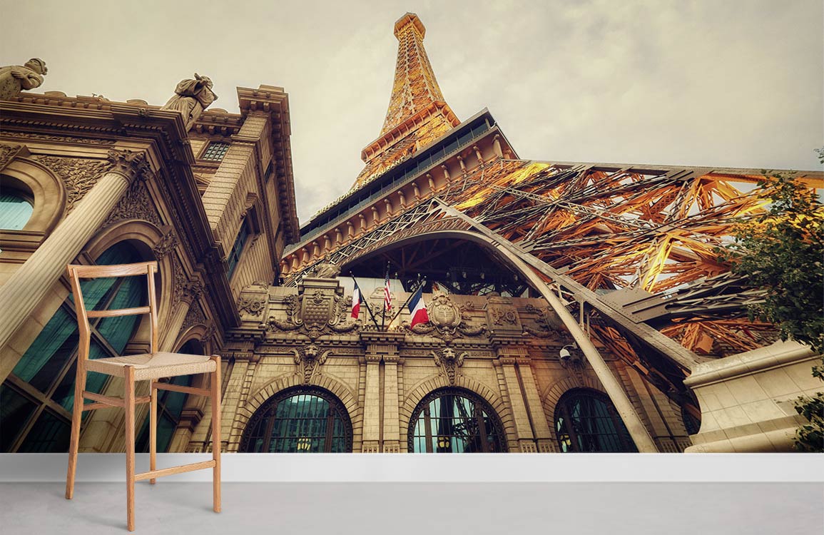 Elegant Parisian mural wallpaper features Eiffel Tower scene, warm tones, wooden chair, minimalist decor.