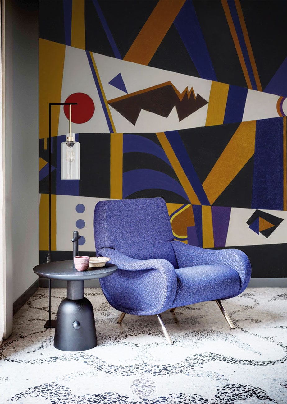 Geometric abstract wallpaper, blue modern armchair, black side table, contemporary living room setting.