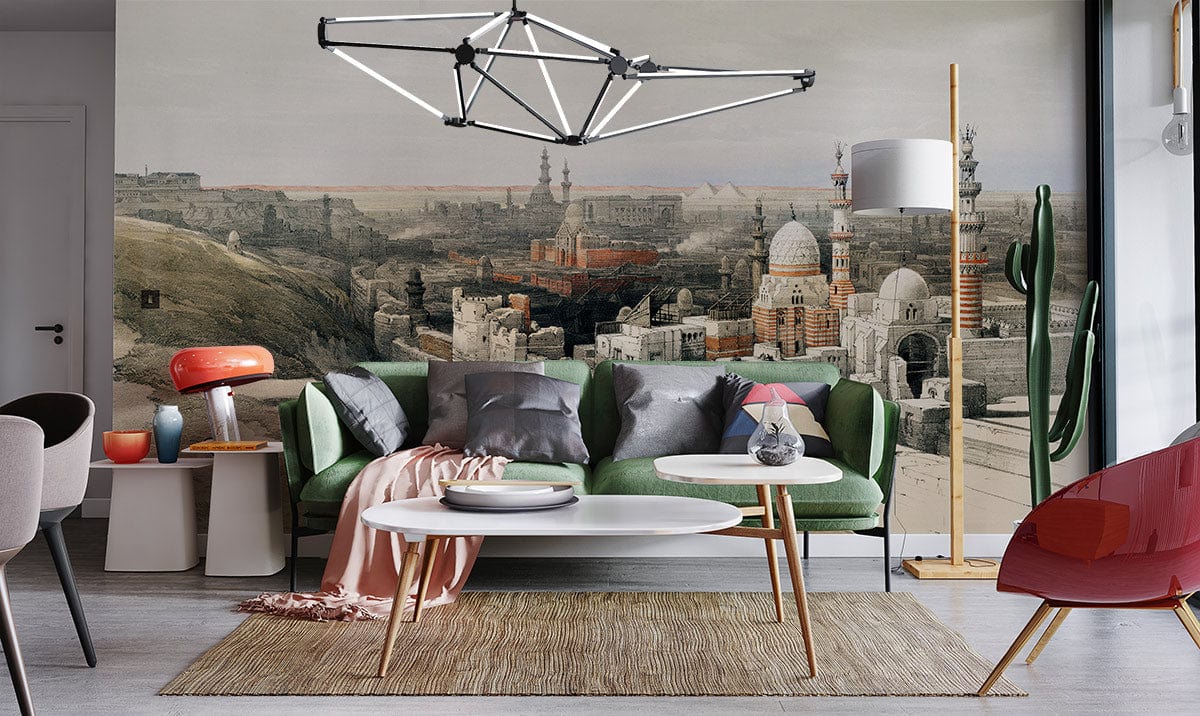Elegant lounge with historical Egyptian cityscape wallpaper, green sofa, and modern lighting fixture.