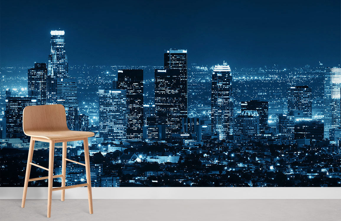 Blue Urban Night Skyline Mural Wallpaper with wooden chair, modern cityscape decor, brightens urban space.