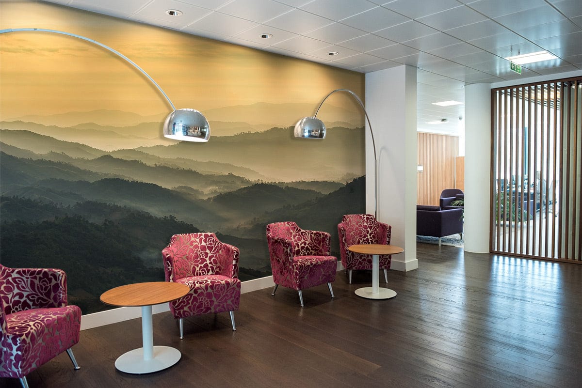 Tranquil Misty Mountains wallpaper in reception area with red patterned chairs, wooden flooring, and lamps.