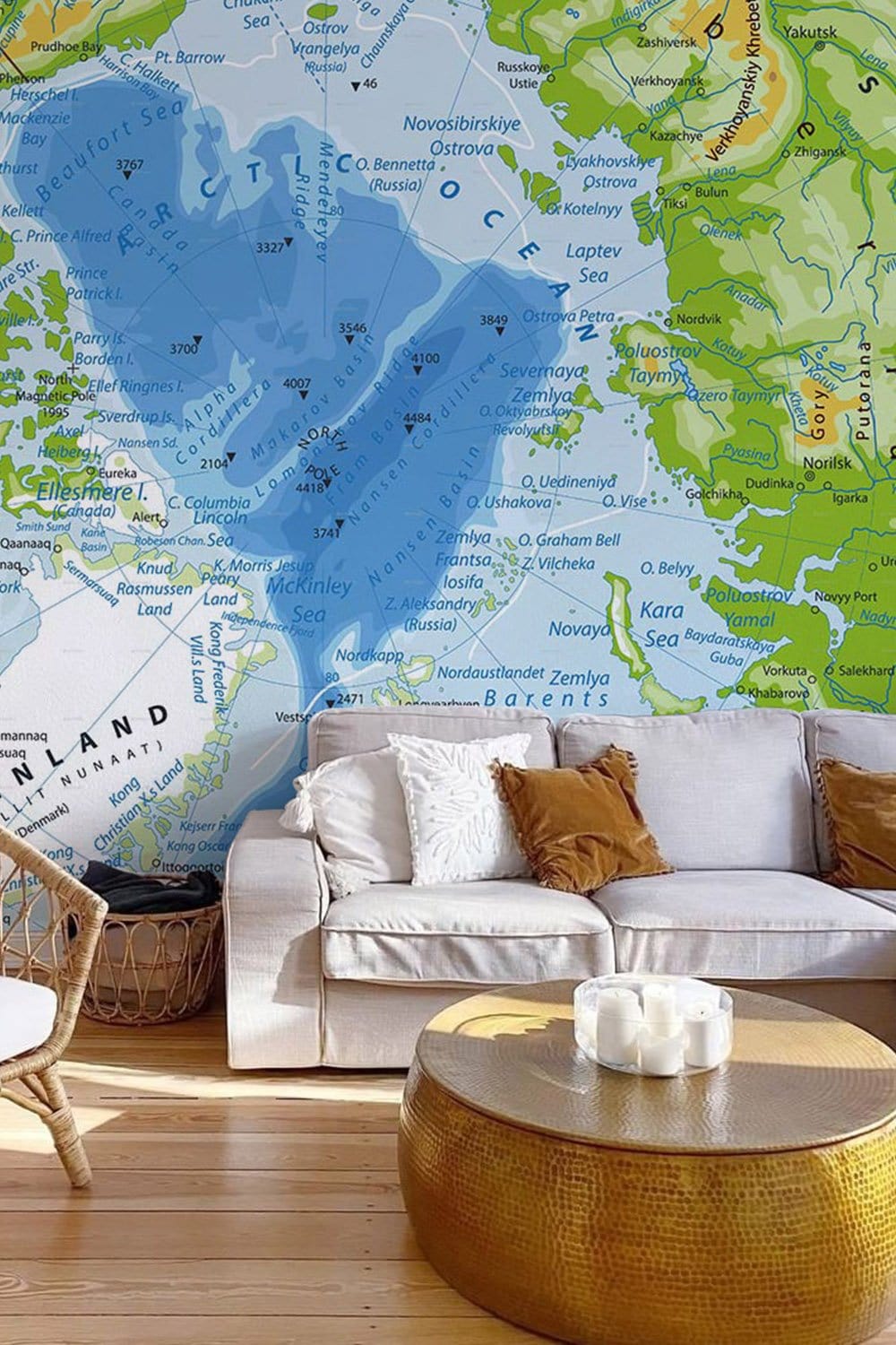 Vintage map mural wallpaper in blue-green tones. Beige sofa, wicker chair, wood flooring, round table.