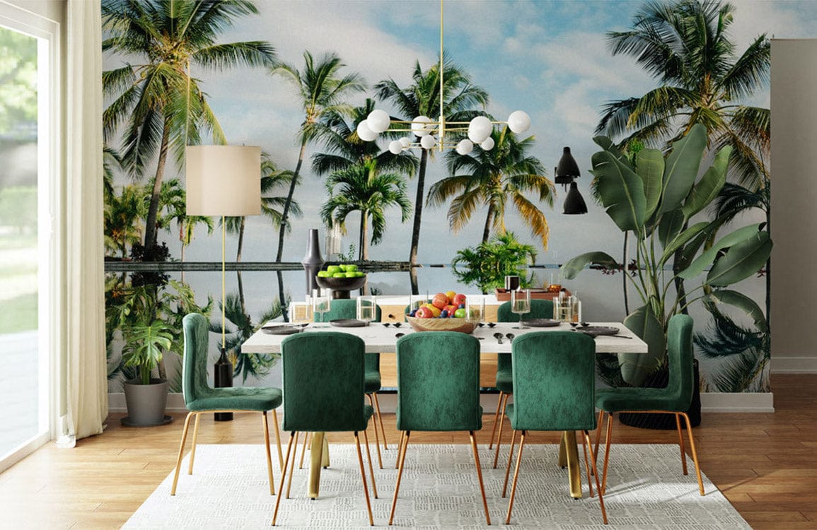 Dining room features tropical palm tree reflection mural wallpaper, green chairs, white table, wooden flooring.