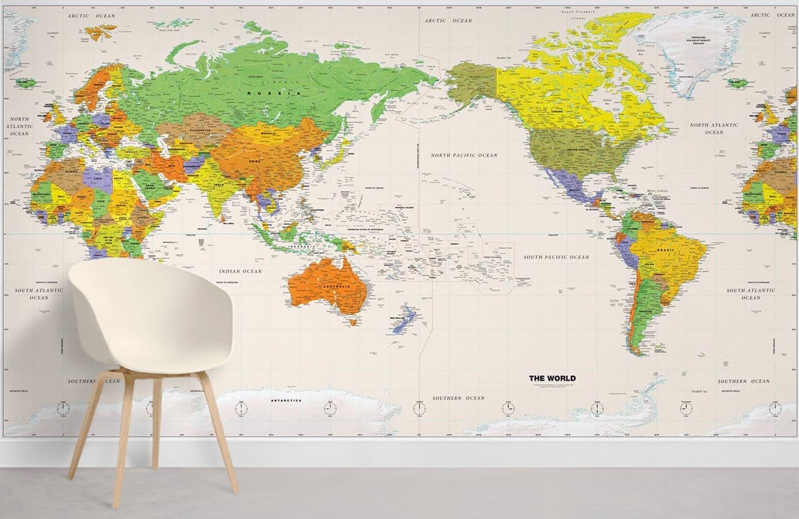 Vibrant World Map Mural Wallpaper in a modern room with white chair and light wood flooring.