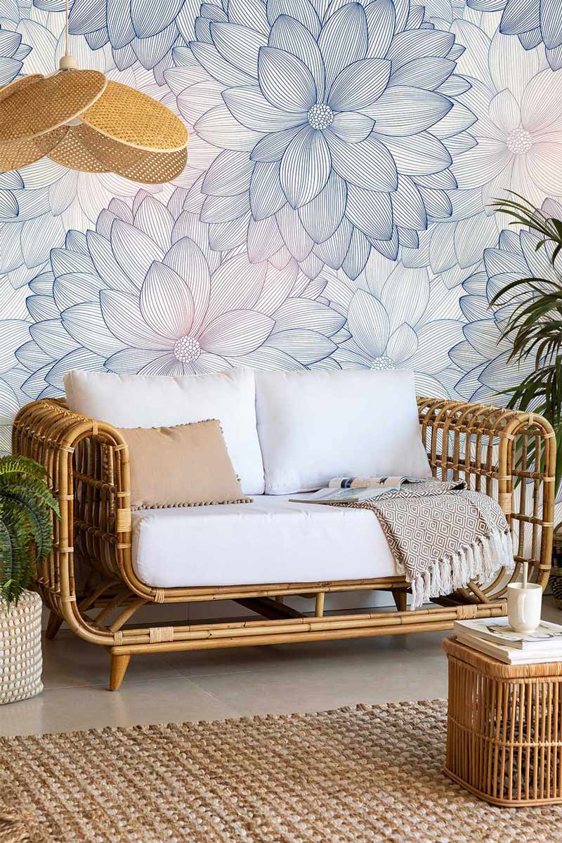Elegant blue and pink floral wallpaper with rattan sofa, beige cushions, and woven rug in seating area.