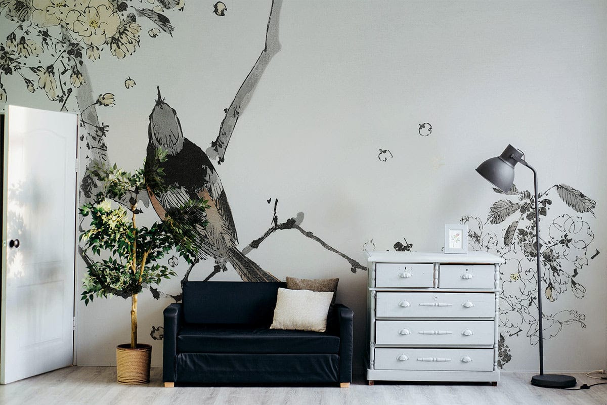 Elegant mural wallpaper with bird design, grey sofa, white dresser, lamp, and wooden flooring.