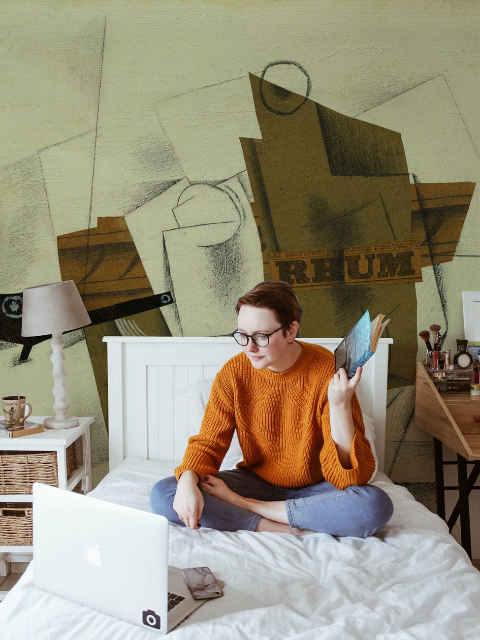 Cubist inspired geometric brown wallpaper design in bedroom with white bed and modern wooden desk.