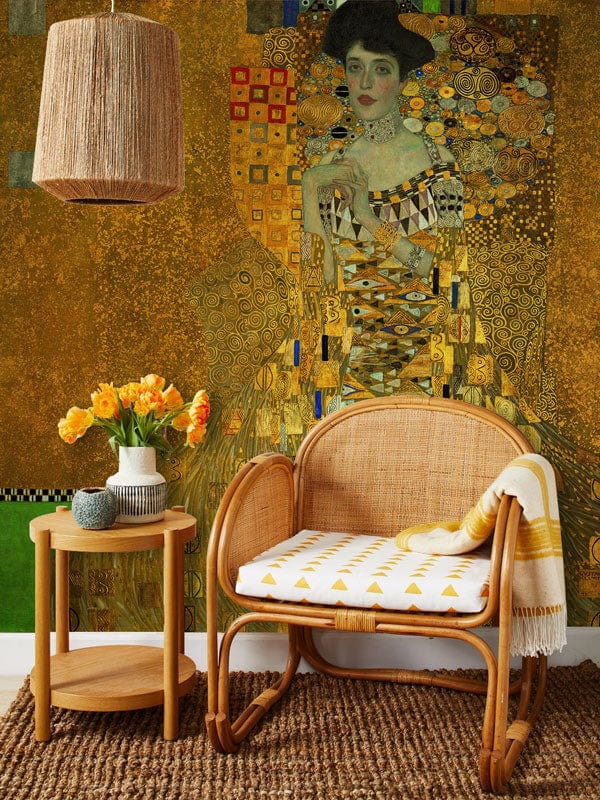Luxurious golden Art Nouveau mural wallpaper with rattan chair, matching lampshade, and textured rug.