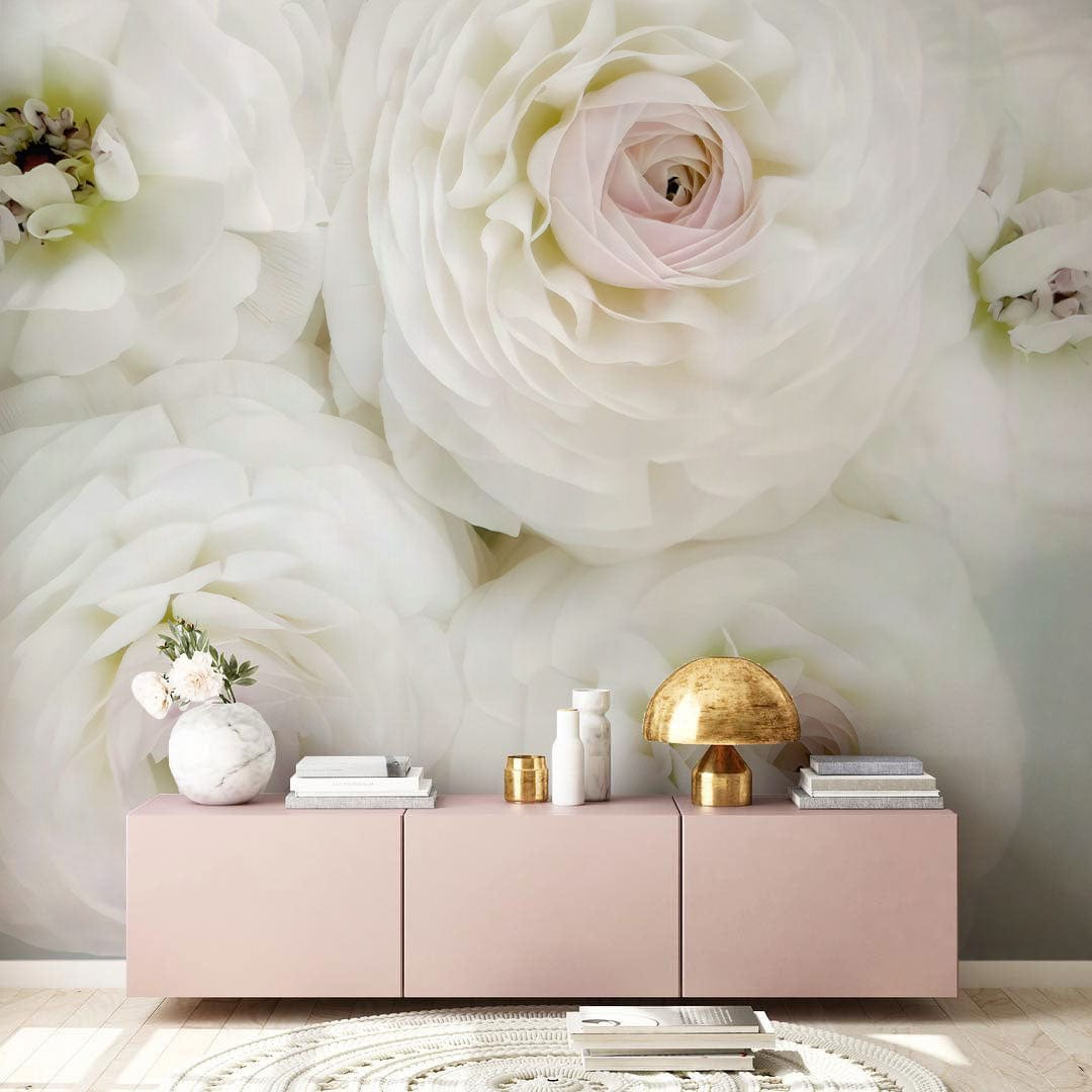 Elegant floral wallpaper mural with pastel accents, pink sideboard, gold lamp, cream rug in living room.
