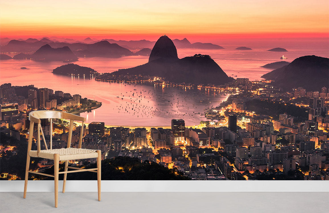 Rio de Janeiro mural wallpaper featuring vibrant pink sunset hues, wooden chair, white skirting, living room.
