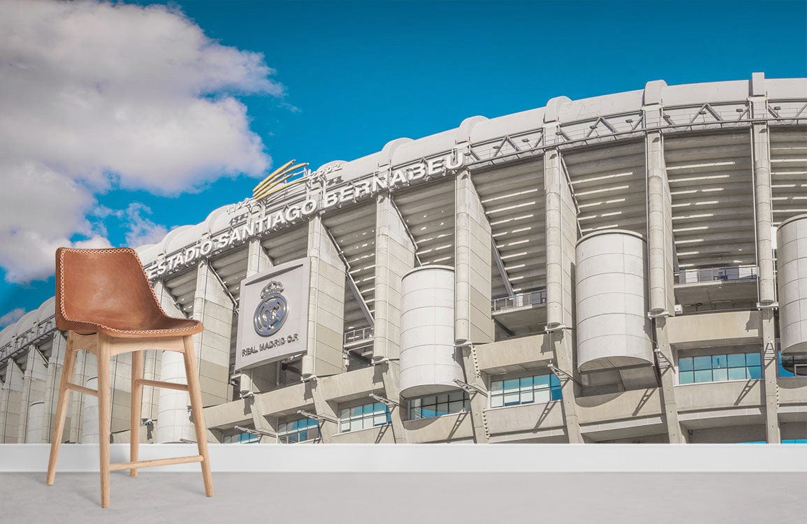 Vintage Santiago Bernabéu Stadium Mural Wallpaper adorning white wall, featuring tan leather bar stool.