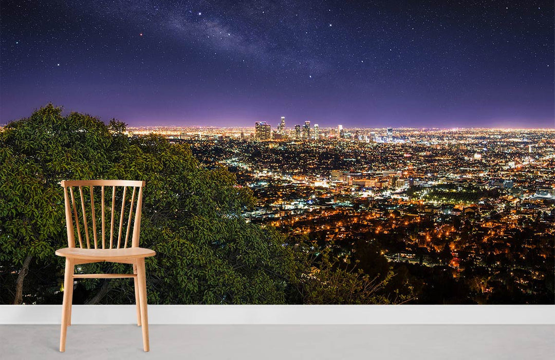 Stunning night cityscape mural wallpaper in living room, featuring urban lights, wooden chair, grey flooring.