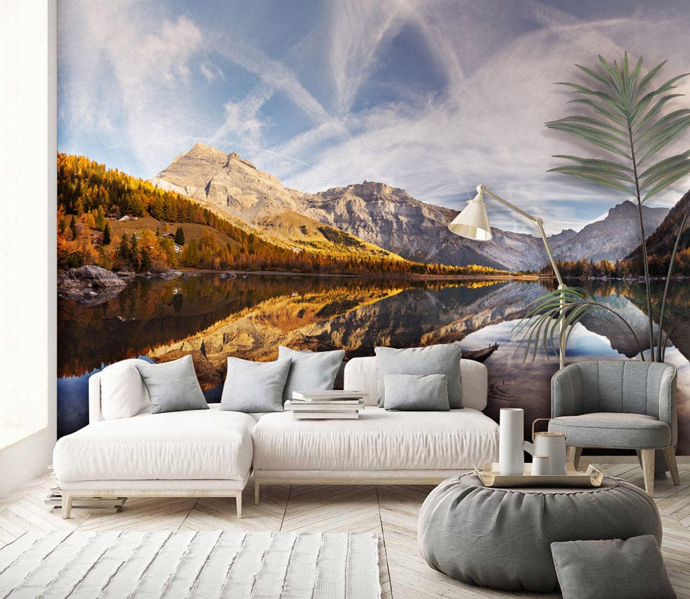 Panoramic mountain lake mural wallpaper in living room with white sofa, grey pouffe, and wooden flooring.