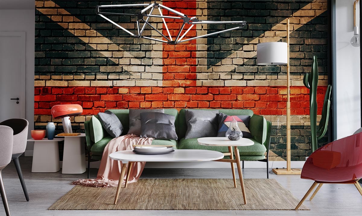Vintage Union Jack Brick Wall Mural Wallpaper in living room featuring green sofa, modern lighting, red chairs.