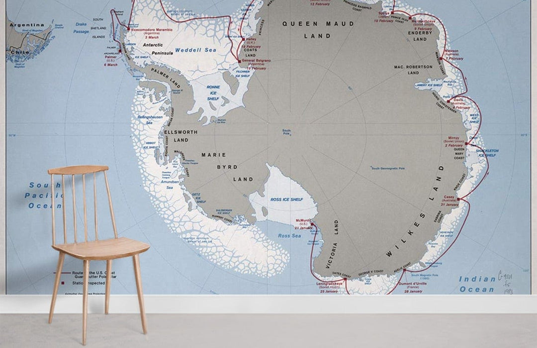 Vintage Antarctic Map Mural Wallpaper in soft earth tones, blue; minimalist chair, light grey flooring.