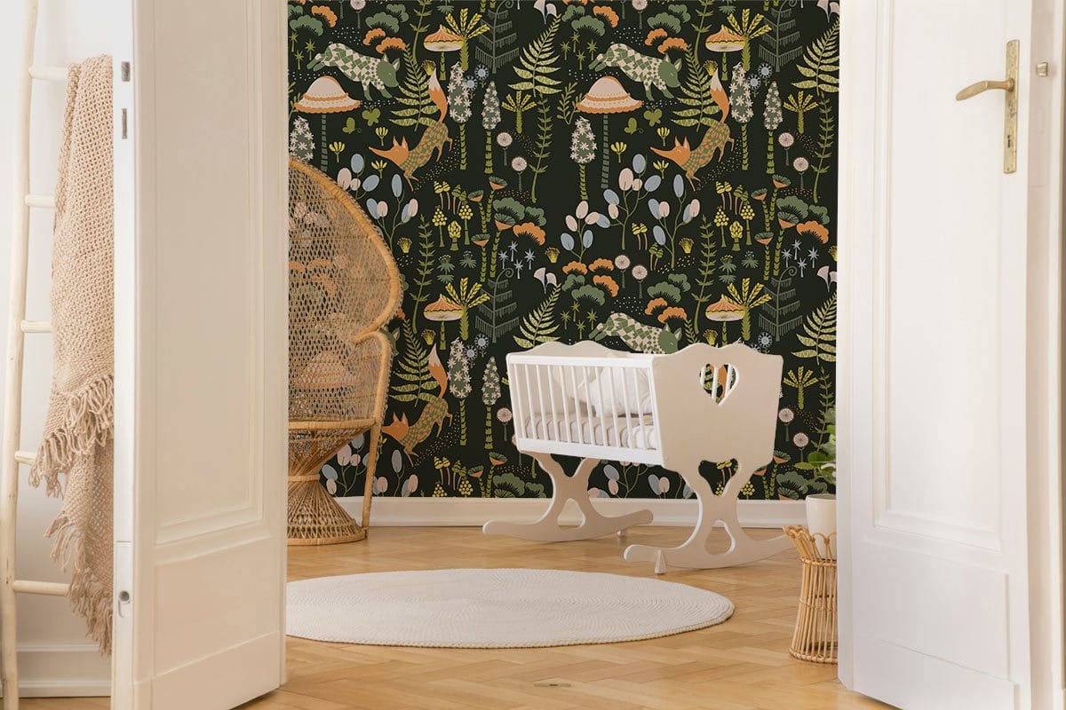 Woodland Forest wallpaper in nursery; white crib, rattan chair, light wood flooring, neutral decor.