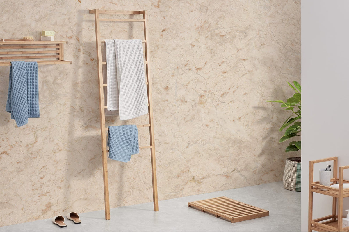Bathroom with Marble-Effect Beige Textured Wallpaper, wooden ladder rack, plant, and light flooring.