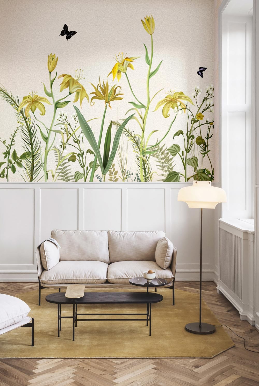 Vintage botanical mural wallpaper, soft yellow-green, minimal sofa, chevron wood flooring, modern floor lamp.
