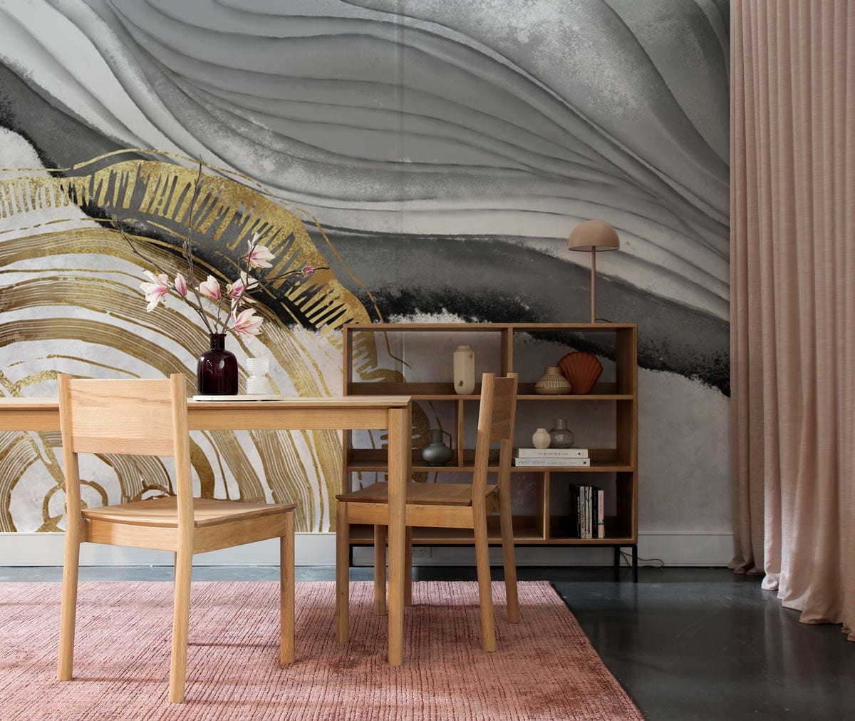 Elegant mural featuring gold and grey abstract design in dining room with pink rug and wooden furniture.