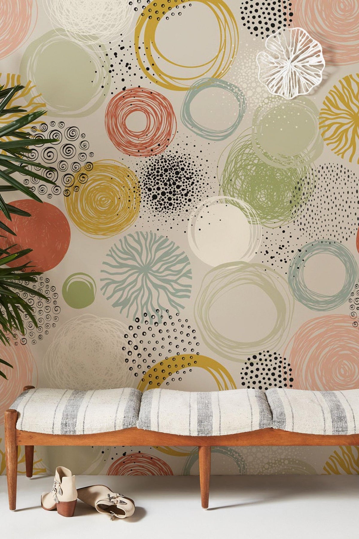 Abstract pastel whirlwind wallpaper with earthy tones in modern room featuring striped bench and plant.