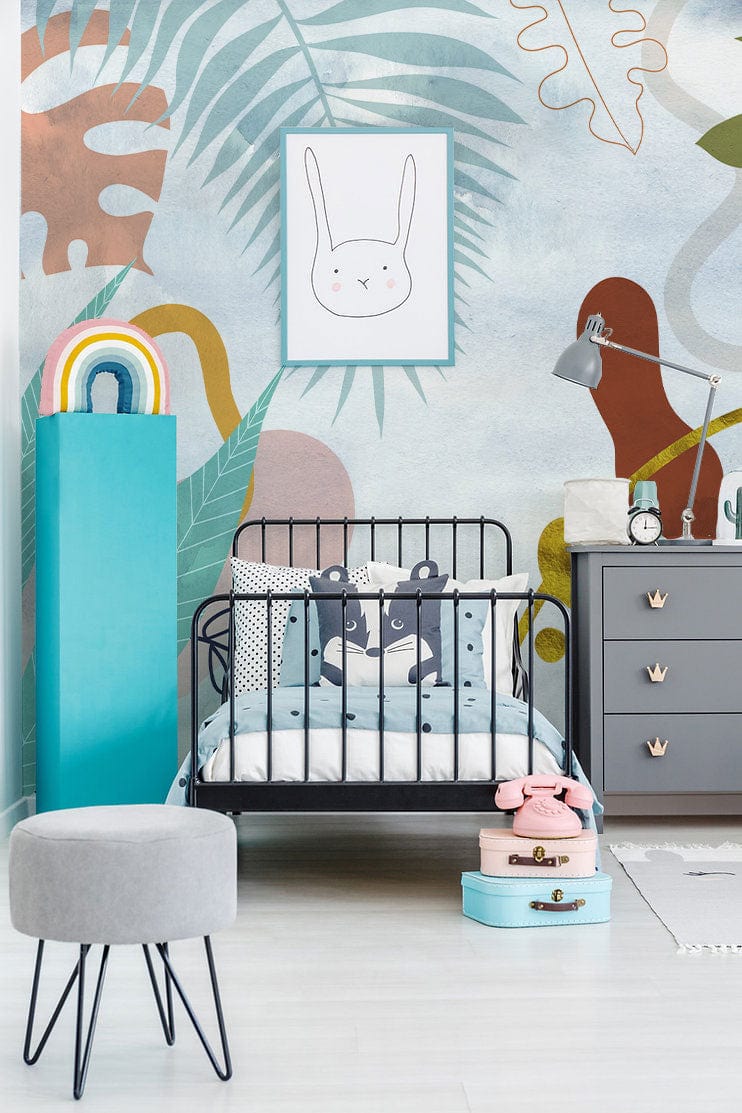 Colourful abstract botanical mural wallpaper in child's room with grey dresser, black bed, light flooring.