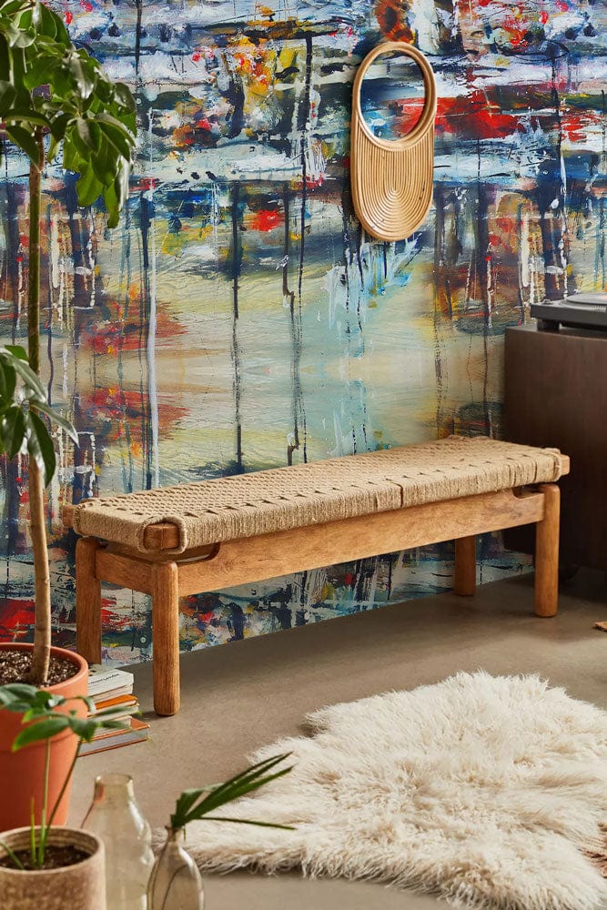 Vibrant abstract mural wallpaper, wicker bench, fluffy rug, contemporary decor, multicoloured design, living room.