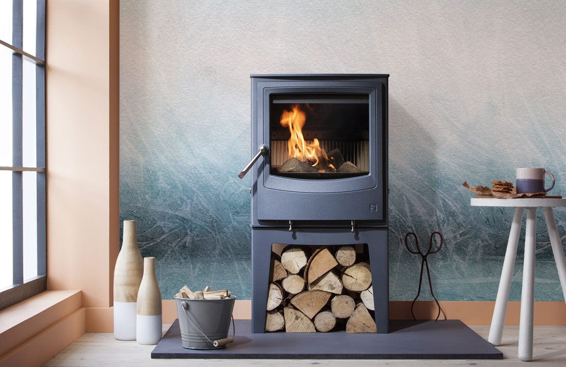 Elegant blue watercolour ombre mural wallpaper behind modern stove in minimalist living room setting.