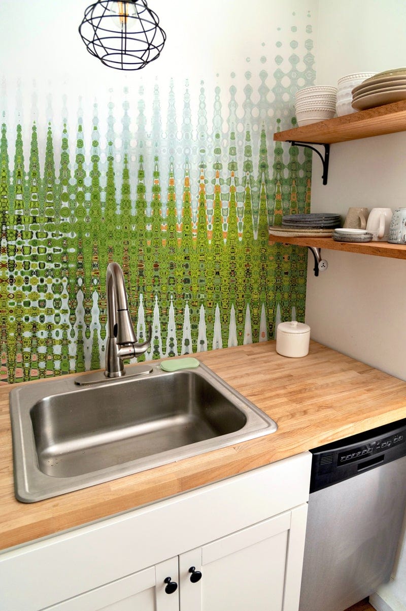 Abstract Green Geometric Pattern Art Wallpaper in modern kitchen with wooden countertops and shelving.
