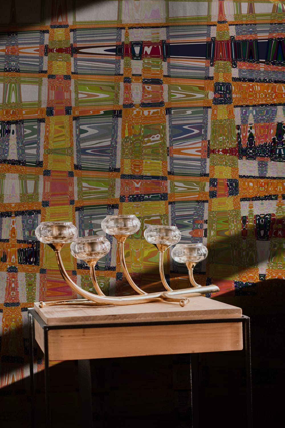 Vibrant abstract mural wallpaper behind modern table, featuring geometric patterns with bold multicolour design.