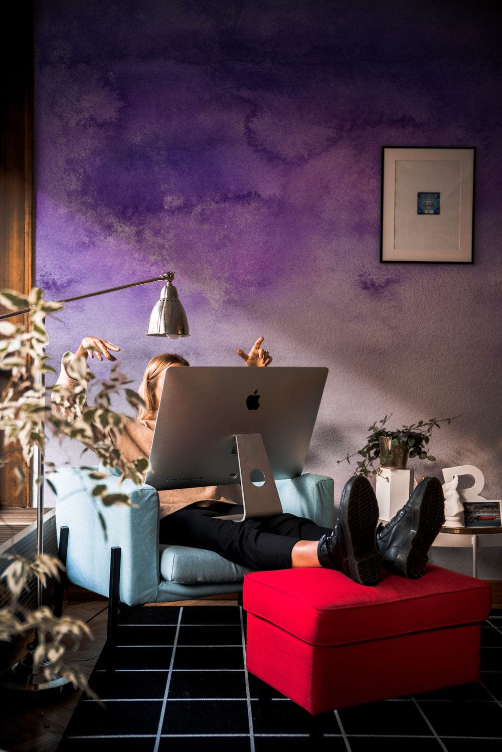 Dreamy Purple Watercolour Ombre Sky Mural Wallpaper, cosy room, blue armchair, red ottoman, framed artwork.