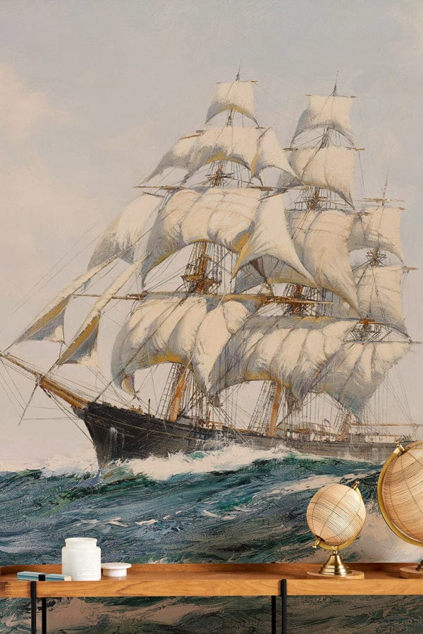 Vintage maritime sailing ship mural wallpaper with globe decor, wooden table, and vibrant ocean waves.