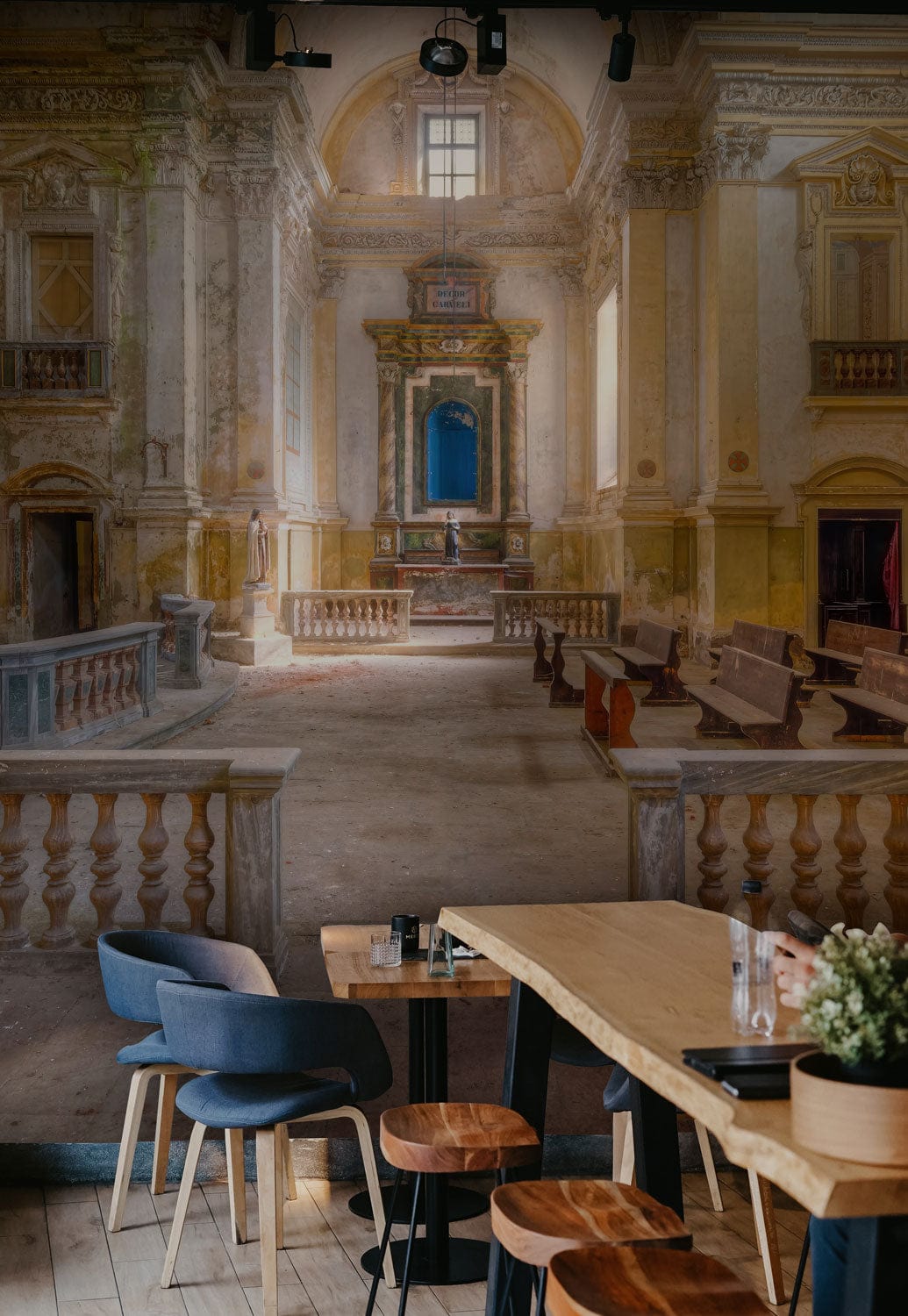 Vintage European Abbey Interior Mural in dining room with wooden table, blue chairs, warm earth tones.