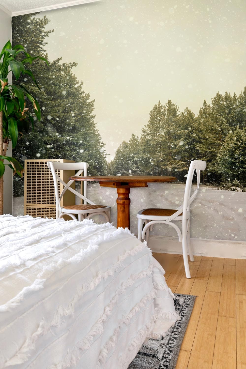 Tranquil Winter Forest Mural Wallpaper, wooden table, rattan chair, serene bedroom, light wooden flooring.
