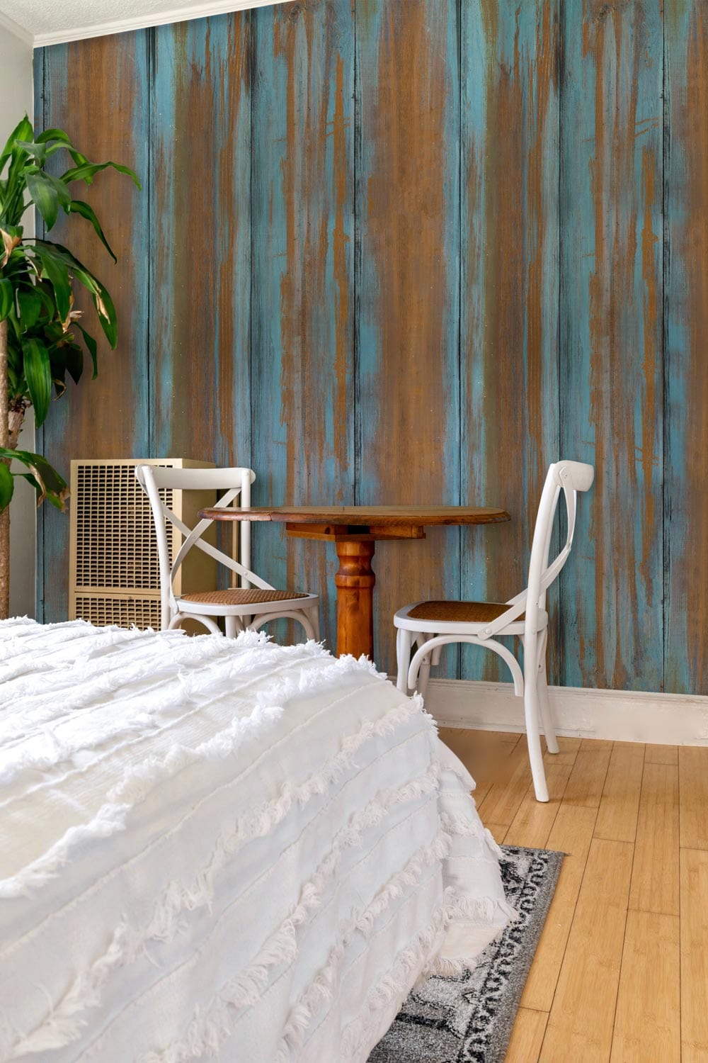Rustic copper and blue striped wallpaper with wooden table, white chairs, and white bed in bedroom.