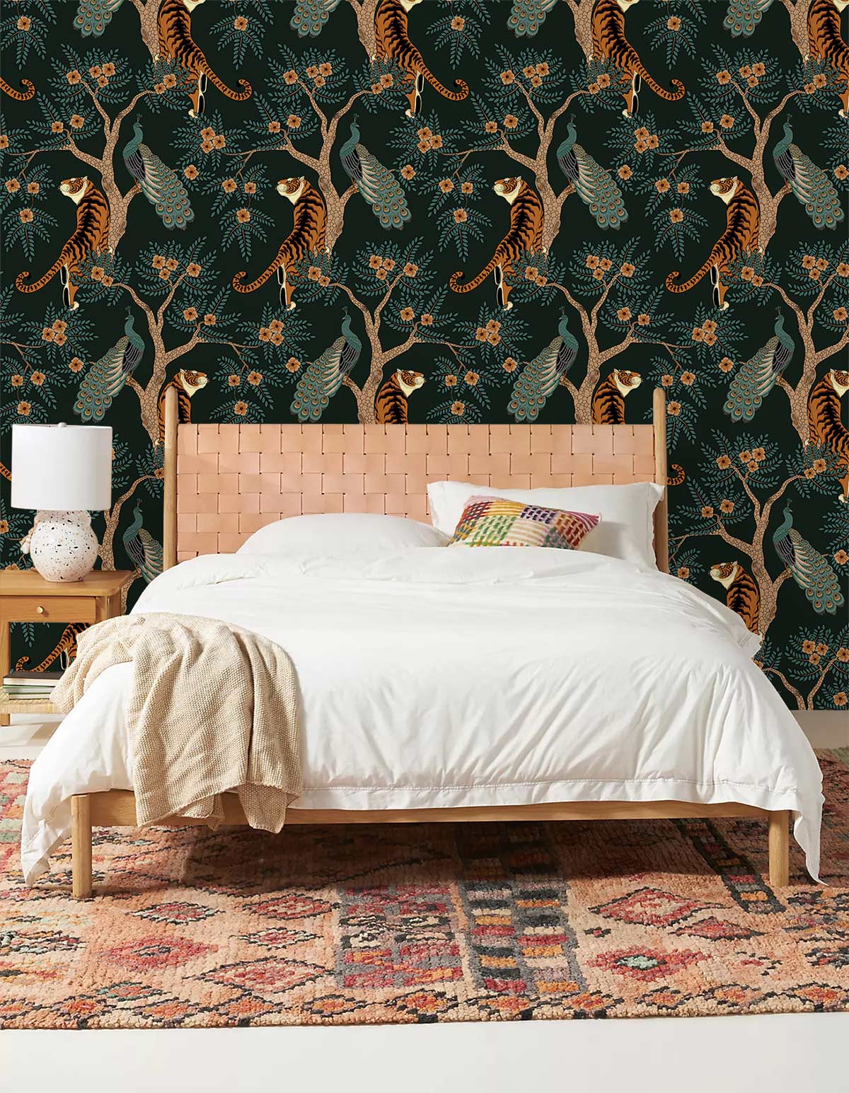 Tropical jungle mural wallpaper with tigers, peacocks; bed with white duvet; patterned rug; bedroom setting.