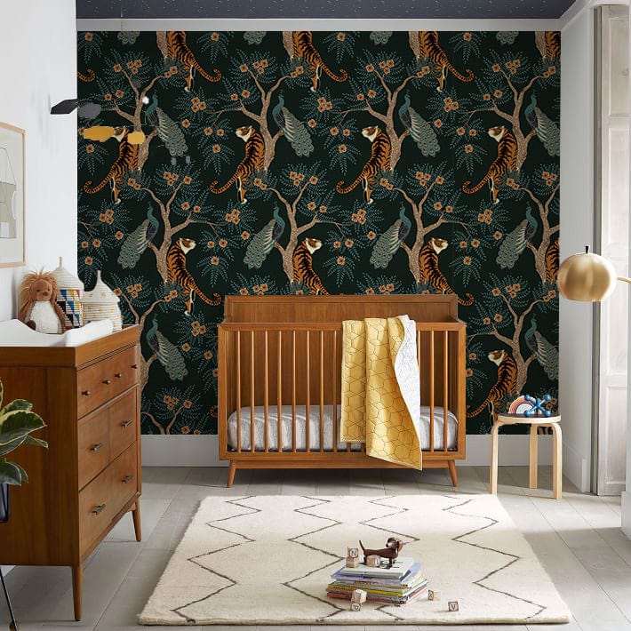 Nursery with Tropical Jungle Wildlife Dark Green Mural Wallpaper, wooden furniture, and modern rug.