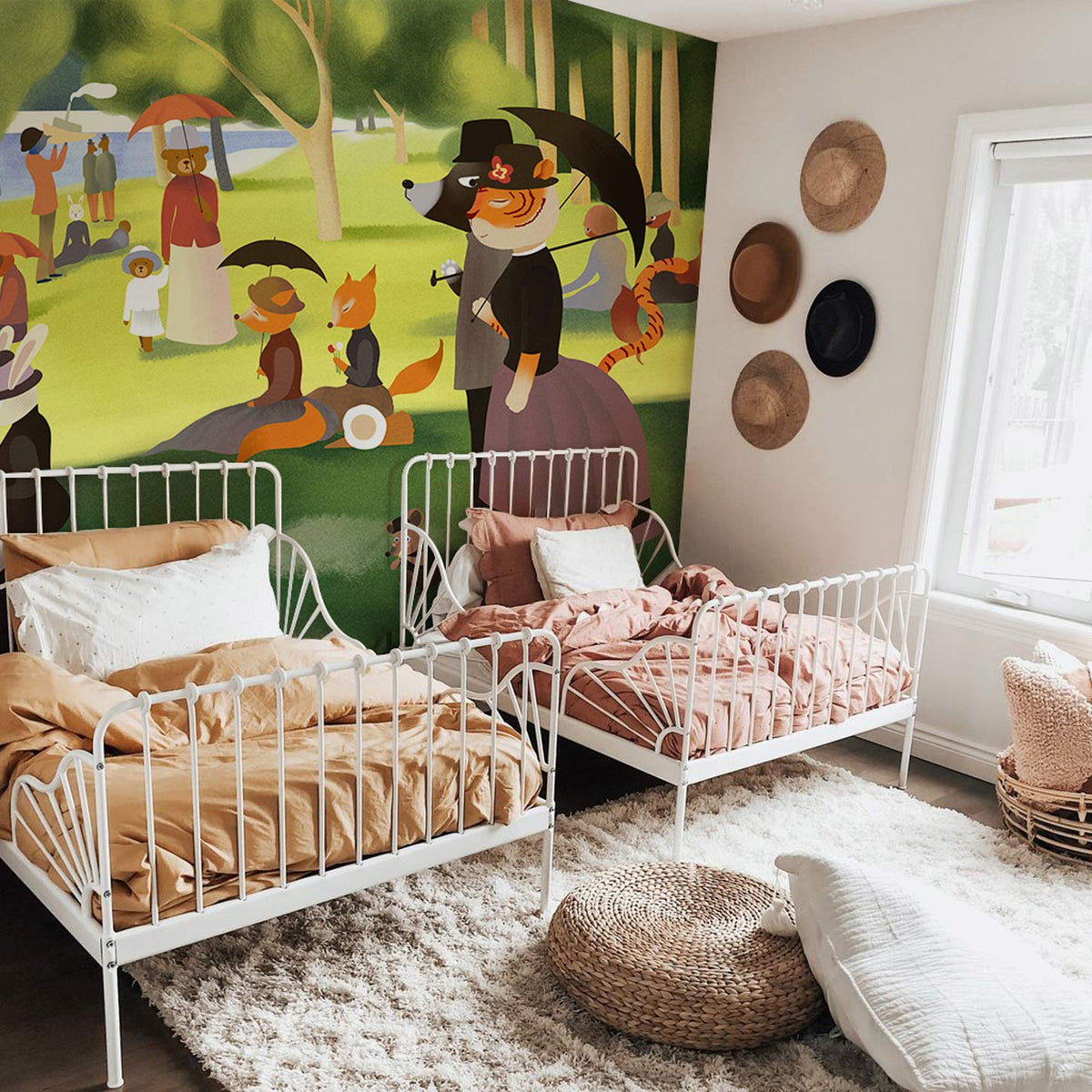 Children's room with Victorian woodland animals mural, white metal beds, cosy beige rug, straw hats.