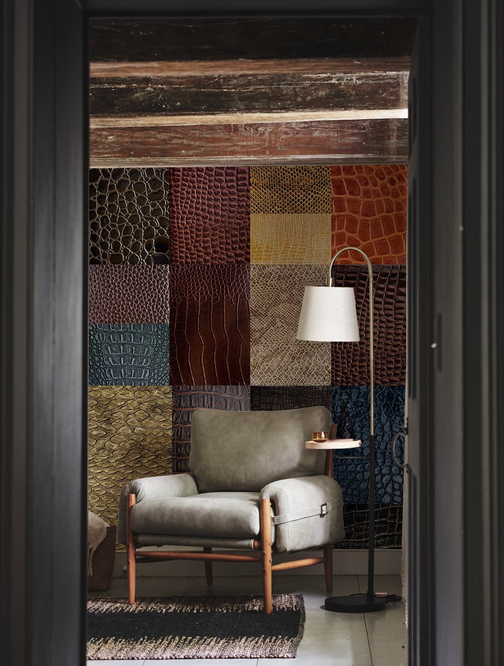 Exotic textured leather wallpaper in colourful design, grey armchair, wooden beams, floor lamp in living room.