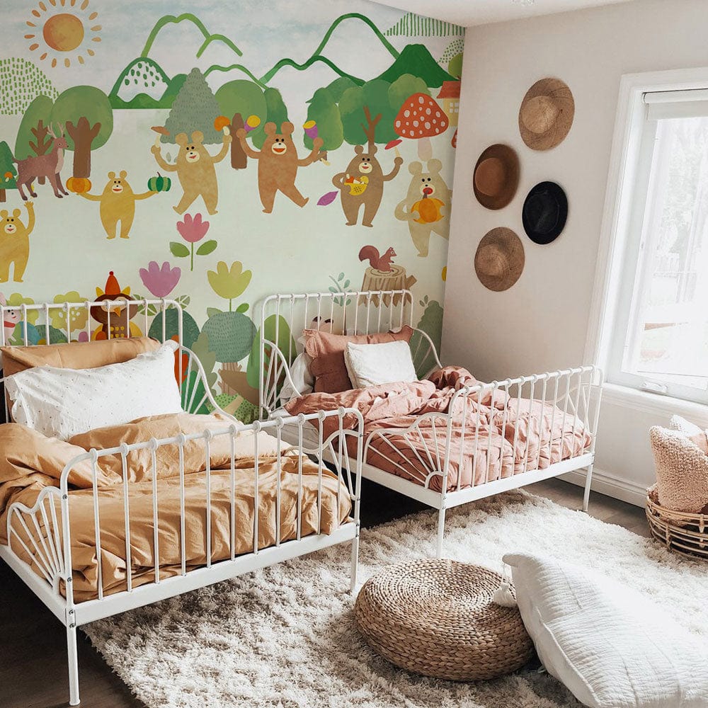 Whimsical Forest Friends mural wallpaper with playful bears, white metal bed frames, and cosy nursery decor.