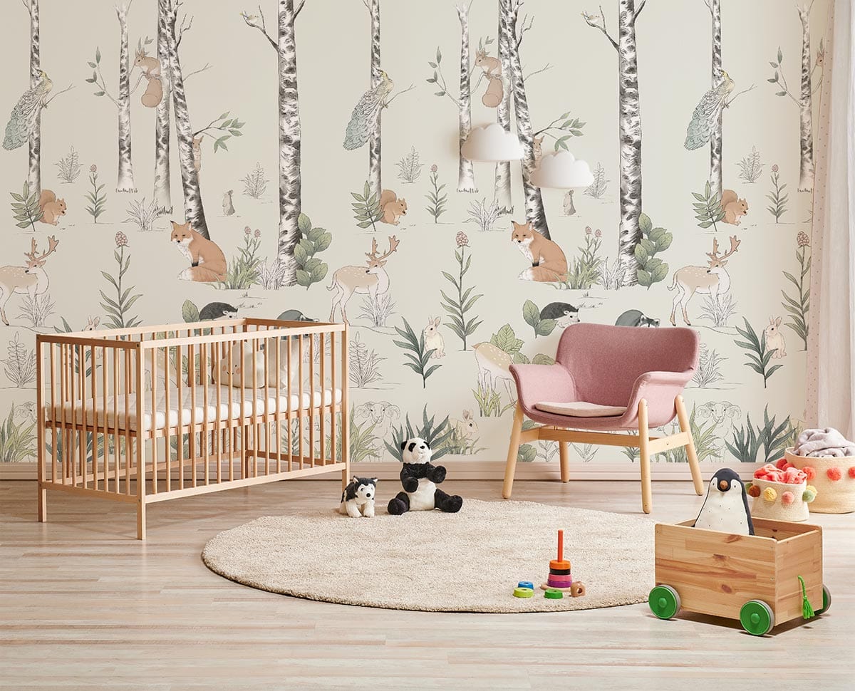 Enchanted Woodland Creatures Pastel Wall Mural in kids' room with wooden cot, pink chair, and toys.